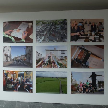 A grid of nine landscape-oriented pictures hangs on a white wall